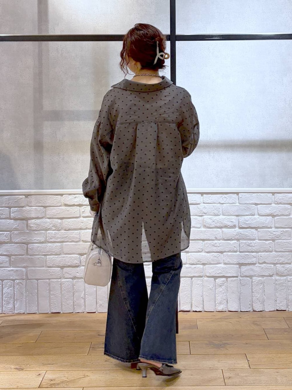 ブルー系のデニムパンツ、ホワイト系のボストンバッグ、ブラウン系のサンダルを着用したレディースの春コーディネートの7枚目の写真