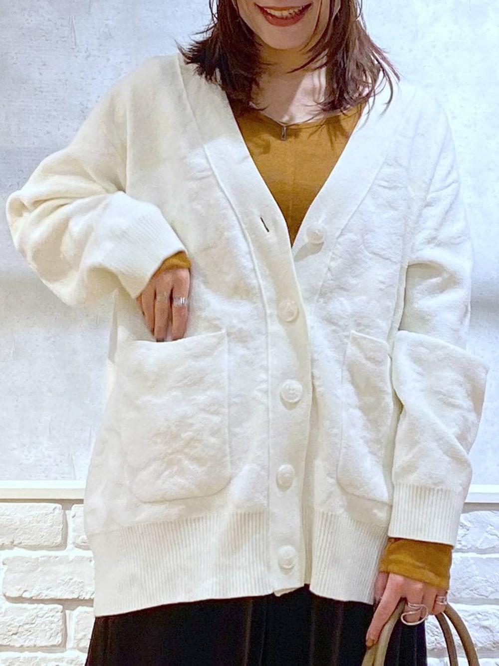 ベージュ系のボストンバッグ、イエロー系のTシャツ/カットソー、ブラック系のローファーを着用したレディースの冬コーディネートの2枚目の写真