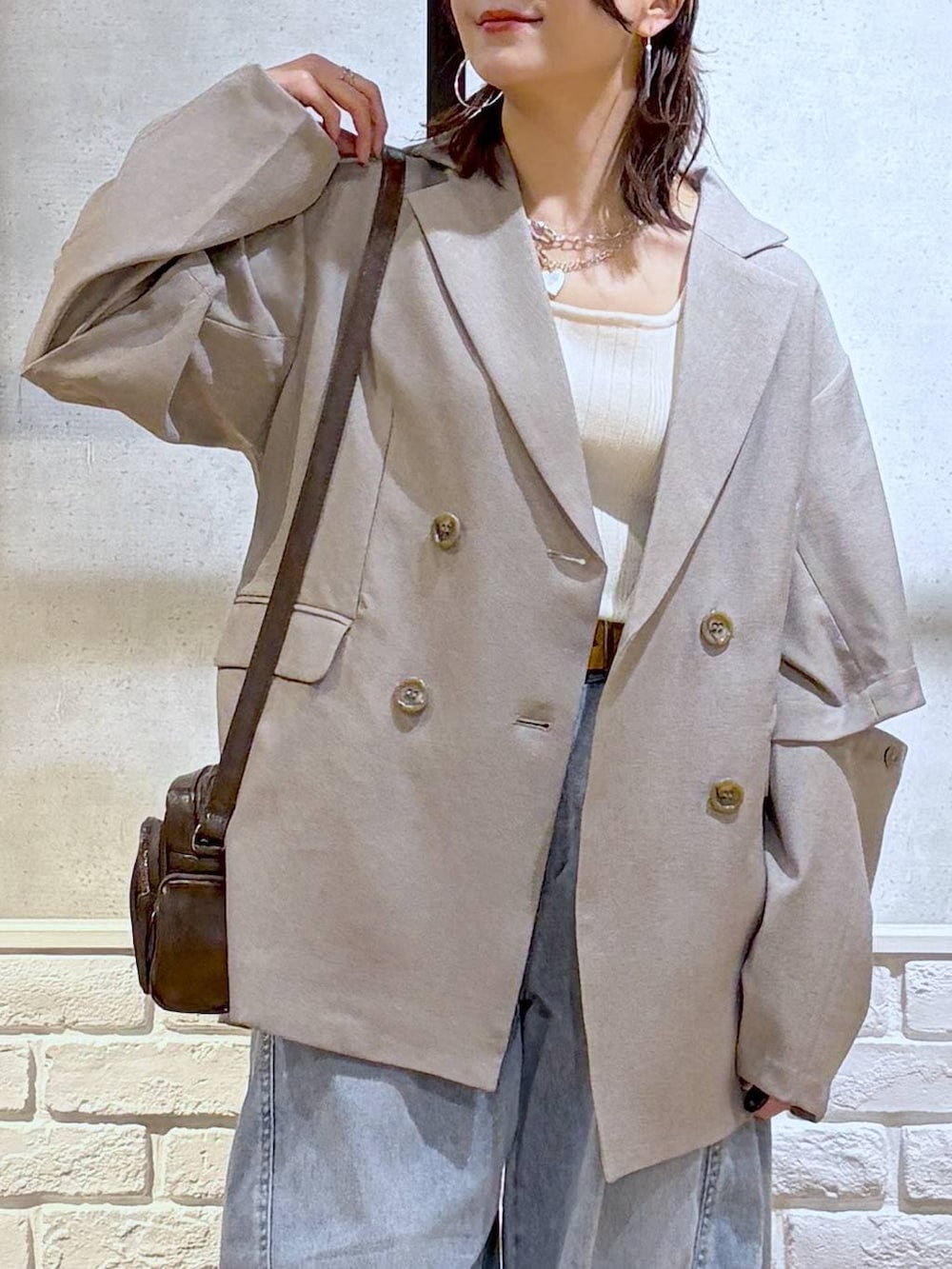 ホワイト系のスニーカー、ホワイト系のタンクトップ、ブラウン系のショルダーバッグを着用したレディースの春コーディネートの2枚目の写真