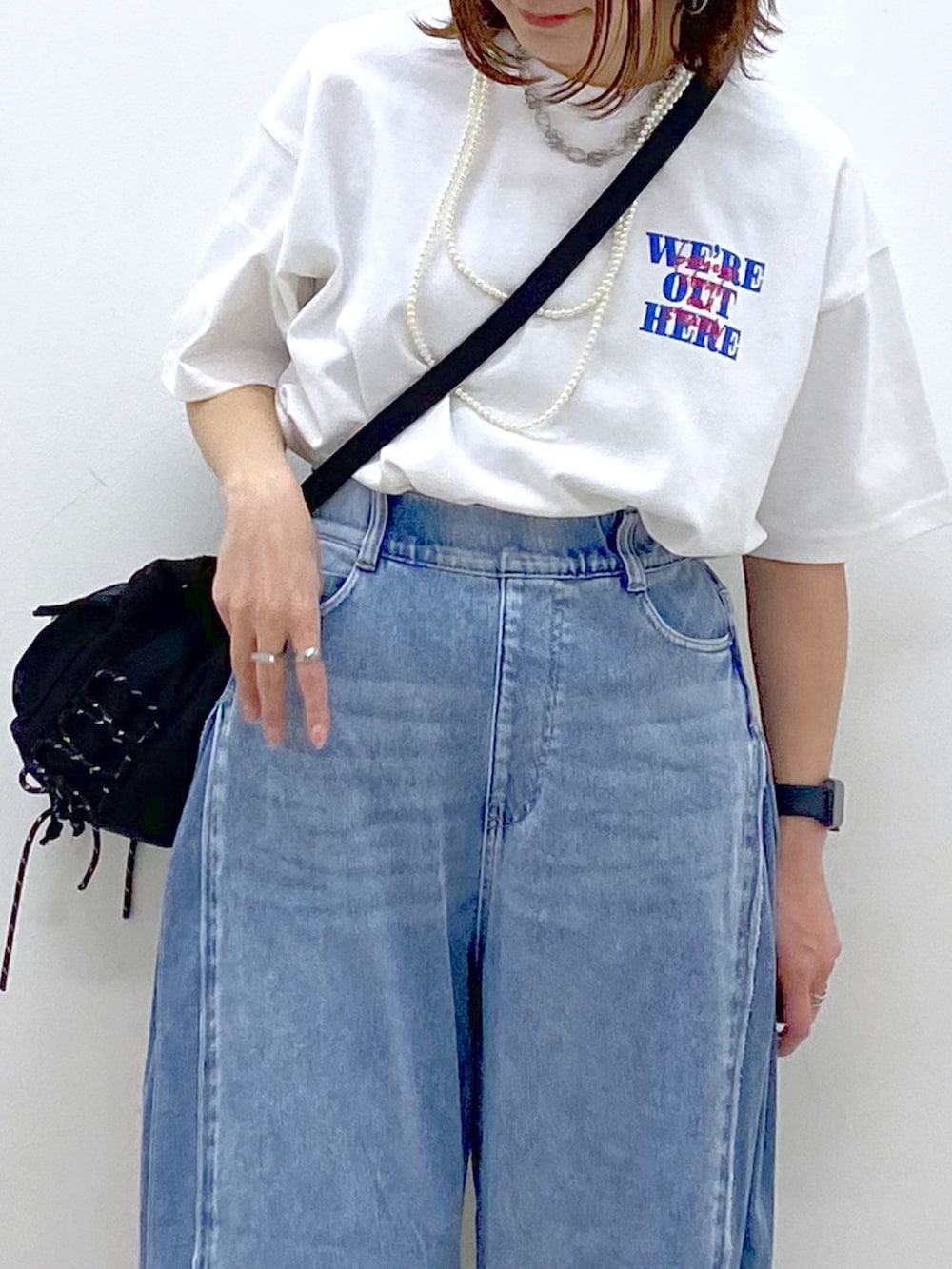 ホワイト系のTシャツ/カットソー、ブラック系のボディバッグ/ウエストポーチ、ブルー系のデニムパンツを着用したレディースの春コーディネートの2枚目の写真