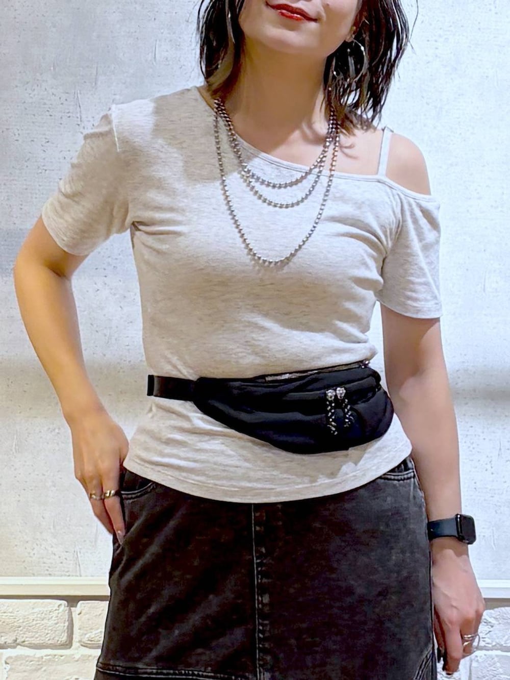 ブラック系のデニムスカート、ブラック系のサンダル、グレー系のTシャツ/カットソーを着用したレディースの夏コーディネートの2枚目の写真