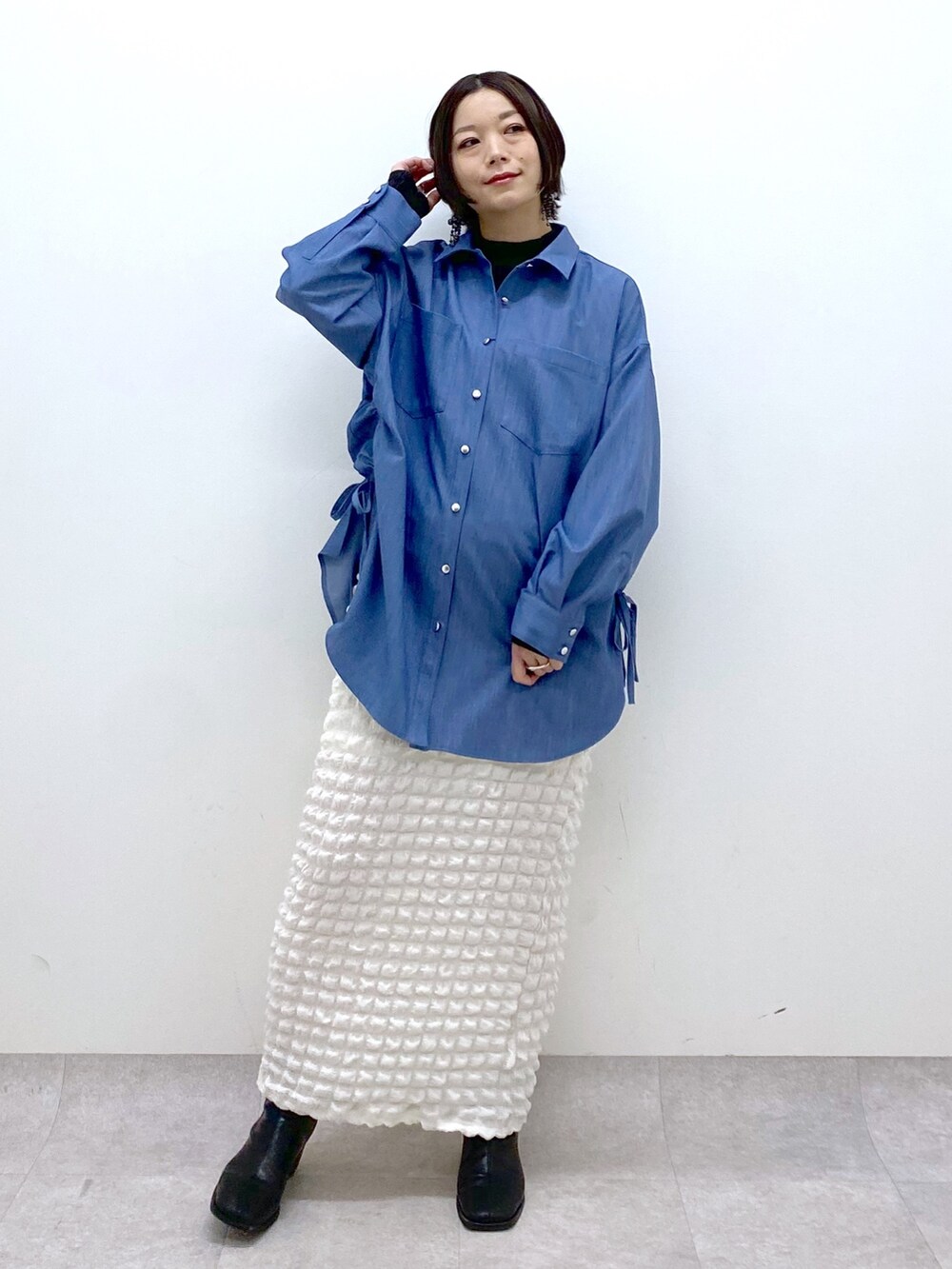 ブルー系のシャツ/ブラウス、ホワイト系のスカート、ホワイト系のシューズを着用したレディースの春コーディネートの2枚目の写真