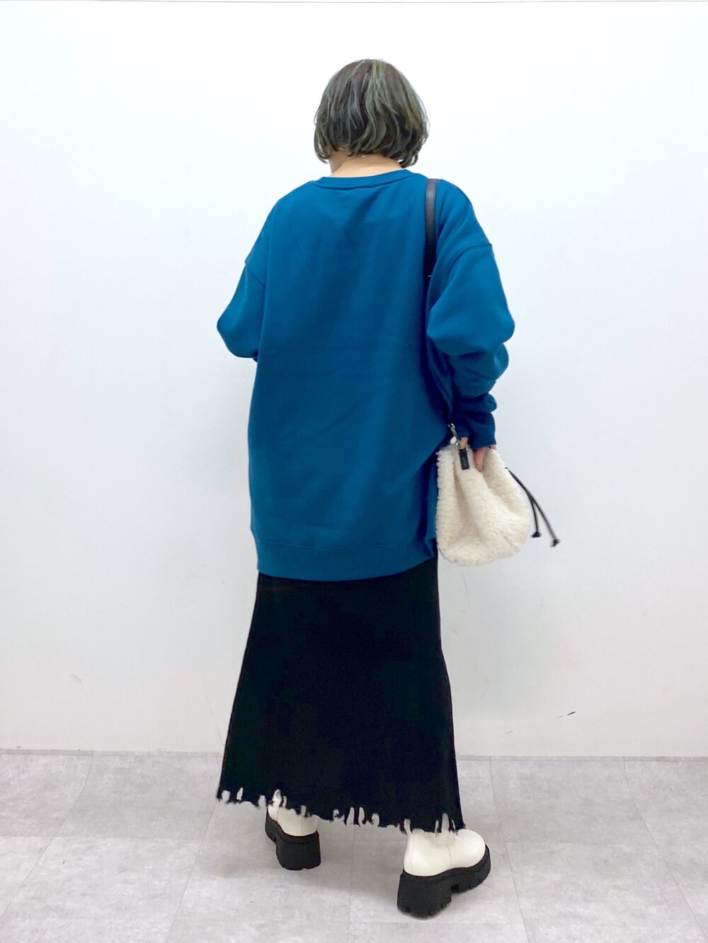 ホワイト系のバッグ、ホワイト系のシューズ、ブラック系のスカートを着用したレディースの冬コーディネートの3枚目の写真