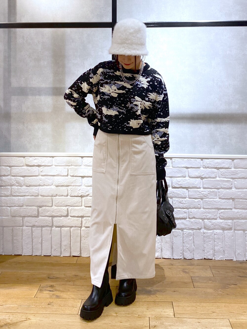 ブラック系のニット/セーター、ブラック系のハンドバッグ、ブラック系のブーツを着用したレディースの冬コーディネートの8枚目の写真