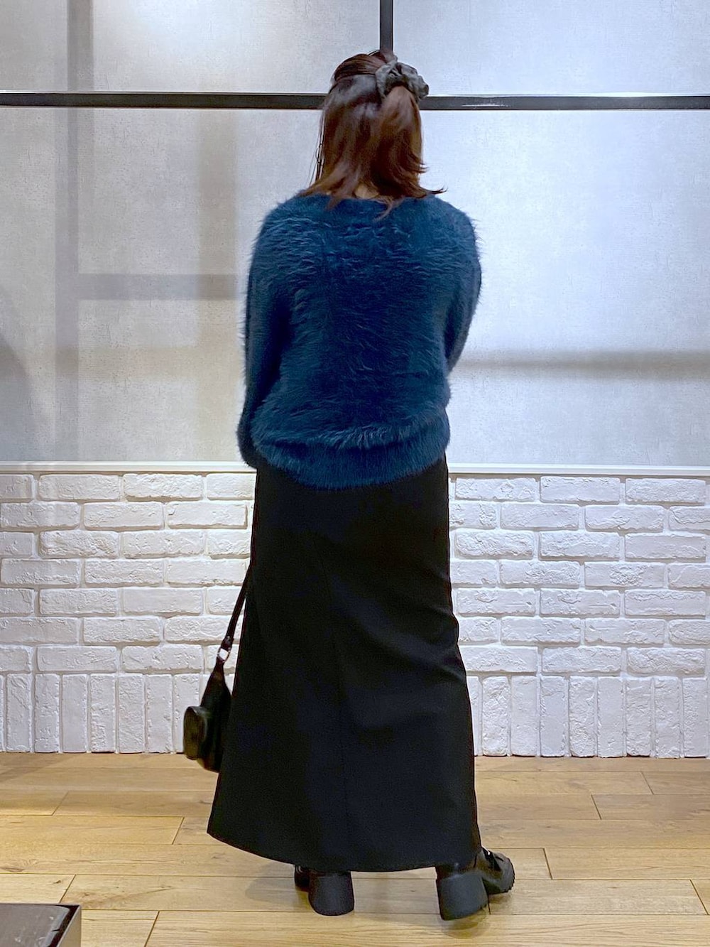 シルバー系のTシャツ/カットソー、ブラック系のブーツ、ブルー系のニット/セーターを着用したレディースの冬コーディネートの7枚目の写真