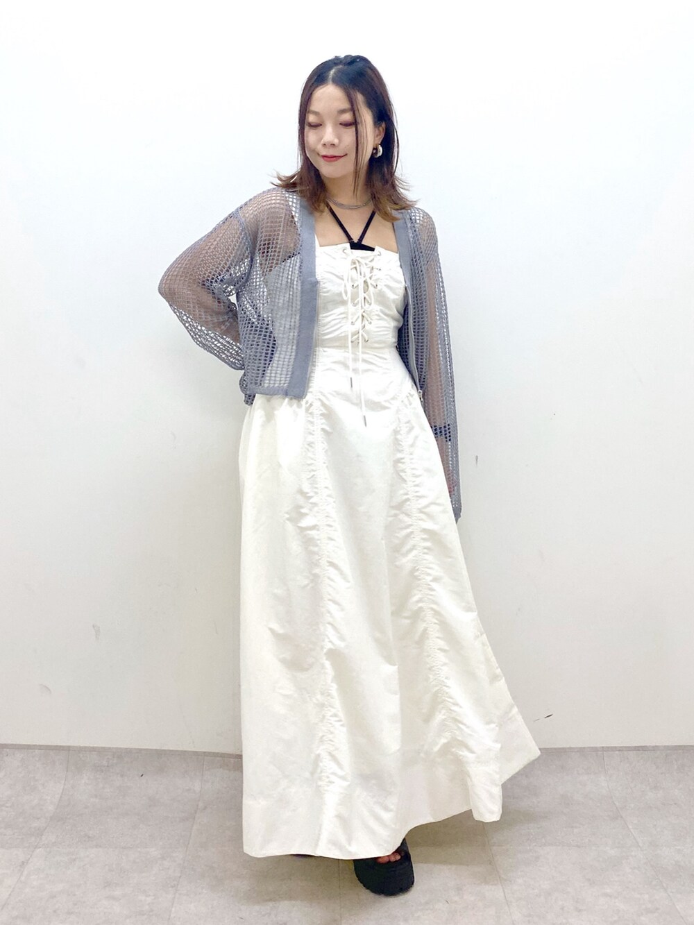 ホワイト系のワンピース、グレー系のカーディガン/ボレロ、ブラック系のサンダルを着用したレディースの春コーディネートの8枚目の写真