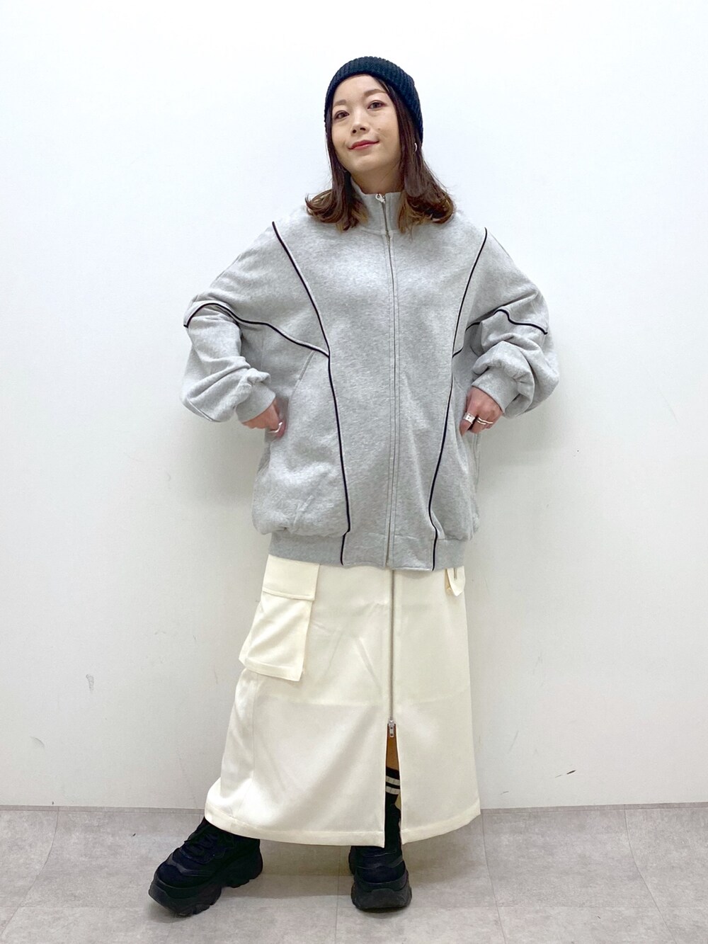 ホワイト系のスカート、ブラック系のスニーカー、グレー系のスウェットを着用したレディースの冬コーディネートの8枚目の写真