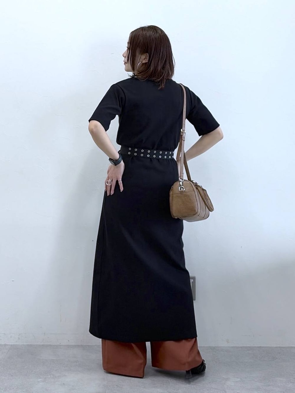 ブラウン系のボストンバッグ、ブラウン系のスラックス、ブラック系のベルトを着用したレディースの春コーディネートの5枚目の写真