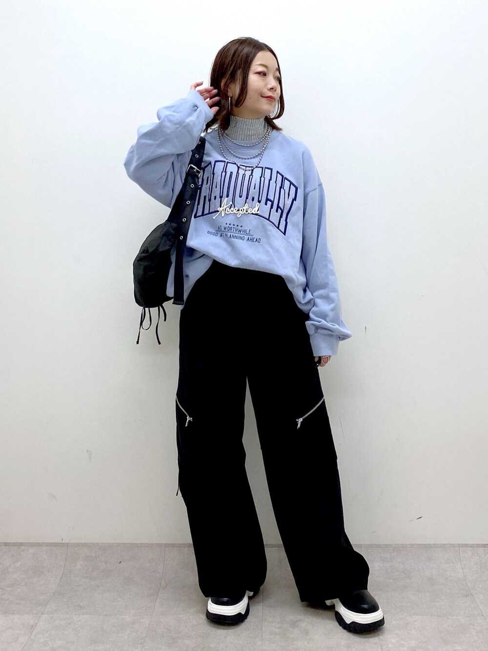 ブルー系のスウェット、ブラック系のカーゴパンツ、ブラック系のブーツを着用したレディースの冬コーディネートの4枚目の写真
