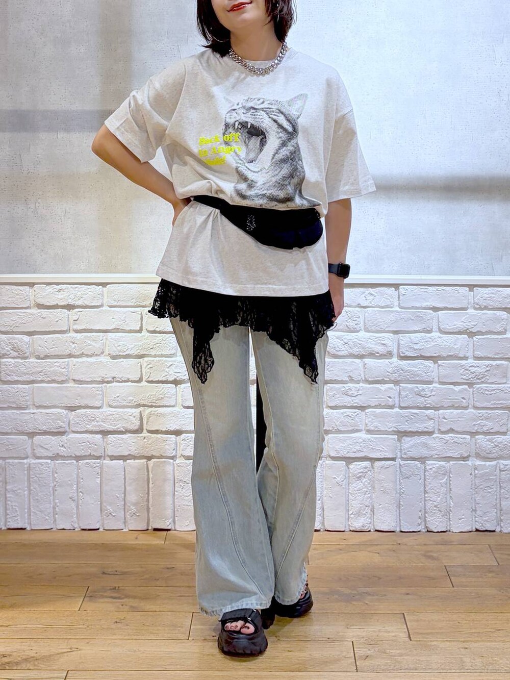 グレー系のTシャツ/カットソー、ブルー系のデニムパンツ、ブラック系のボディバッグ/ウエストポーチを着用したレディースの春コーディネートの3枚目の写真