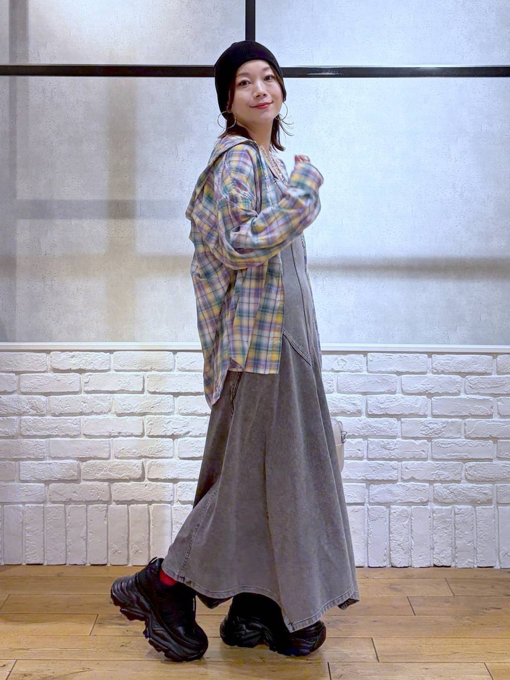 ブラック系のスニーカー、ホワイト系のボストンバッグ、ブラック系のワンピースを着用したレディースの春コーディネートの7枚目の写真