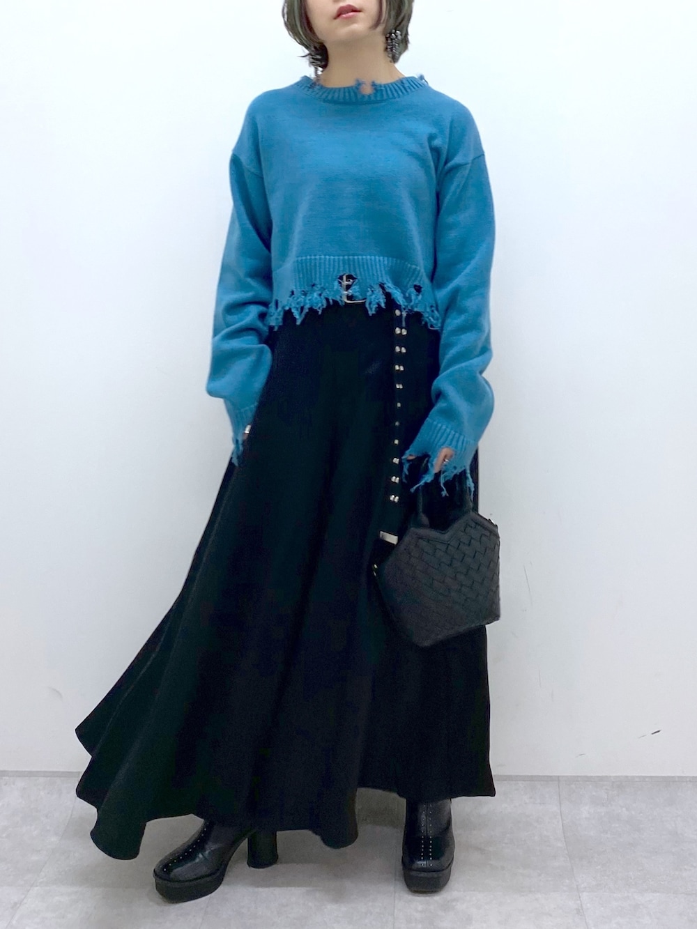 ブラック系のショルダーバッグ、ブラック系のスラックス、ブラック系のブーツを着用したレディースの冬コーディネートの4枚目の写真