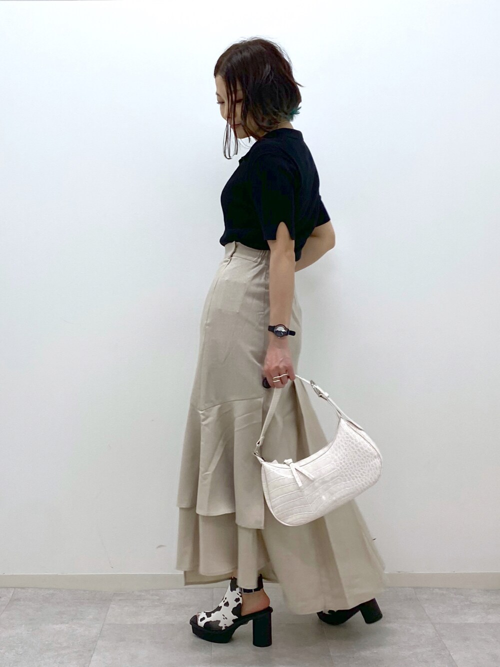 ホワイト系のショルダーバッグ、ベージュ系のスカート、ホワイト系のサンダルを着用したレディースの春コーディネートの2枚目の写真