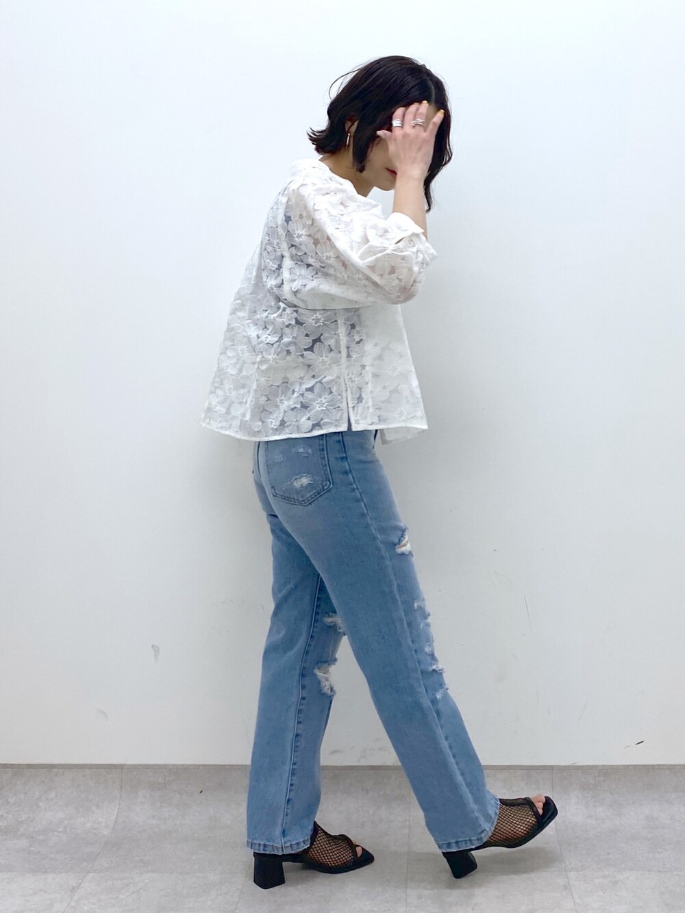 ブルー系のパンツ、ホワイト系のシャツ/ブラウス、ブラック系のトップスを着用したレディースの春コーディネートの2枚目の写真