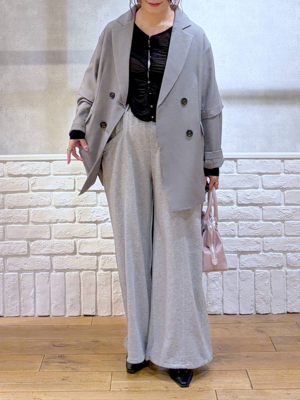 ピンク系のハンドバッグ、グレー系のスウェットパンツ、ブラック系のサンダルを着用したレディースの春コーディネートの2枚目の写真