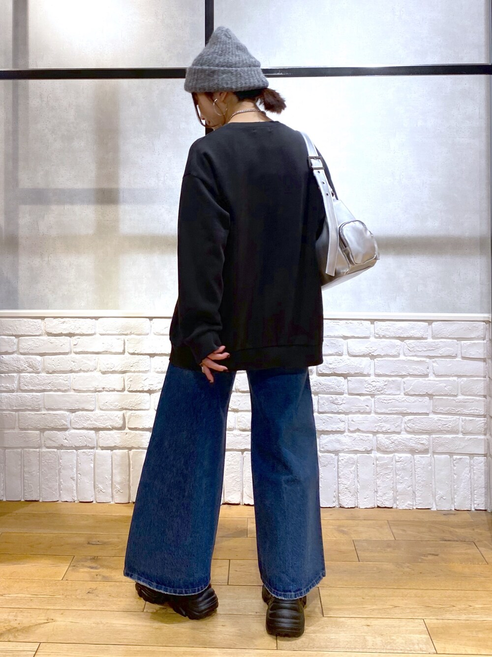 グレー系のスウェット、ブルー系のデニムパンツ、ブラウン系のブーツを着用したレディースの冬コーディネートの6枚目の写真