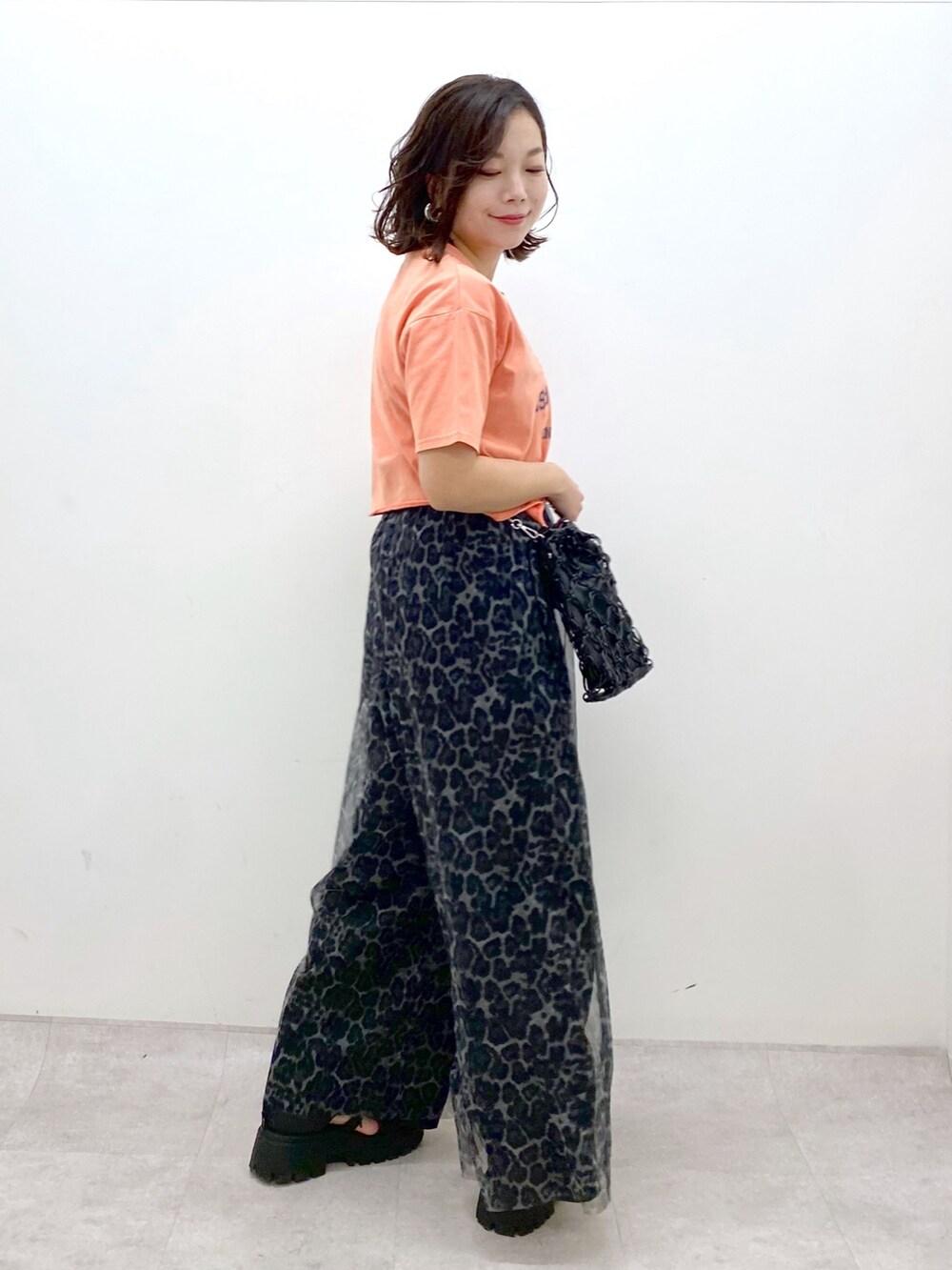 ピンク系のTシャツ/カットソー、グレー系のその他パンツ、ブラック系のサンダルを着用したレディースの春コーディネートの6枚目の写真