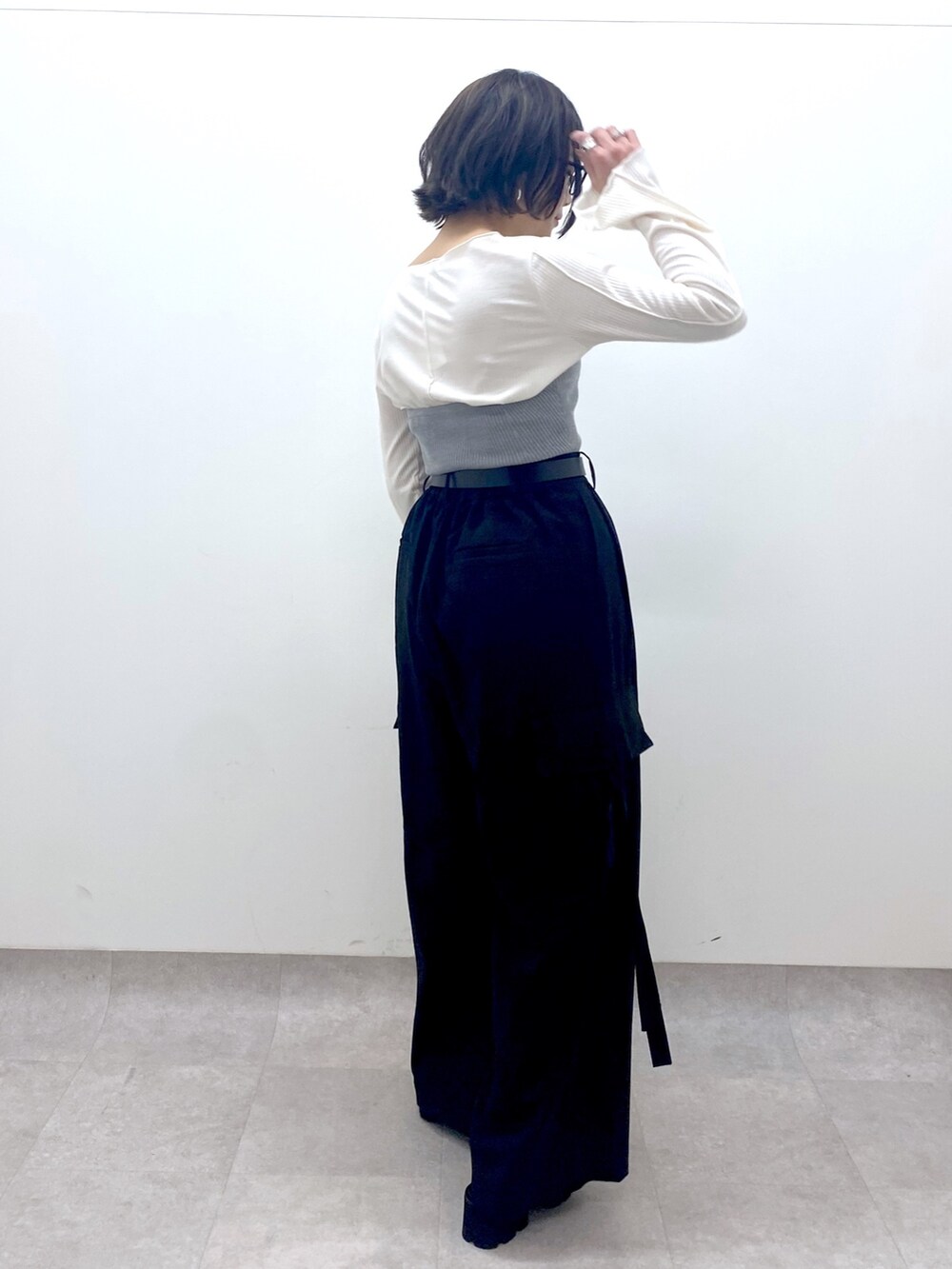 ブラック系のパンツ、グレー系のトップス、ホワイト系のトップスを着用したレディースの春コーディネートの2枚目の写真