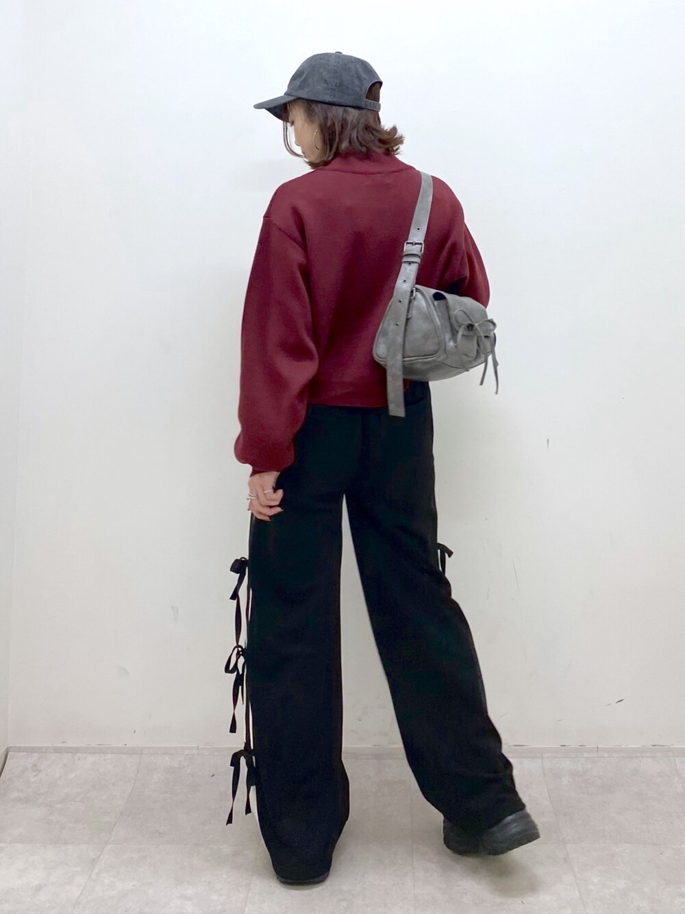 レッド系のニット/セーター、ブラック系のその他パンツ、ブラック系のブーツを着用したレディースの秋コーディネートの7枚目の写真