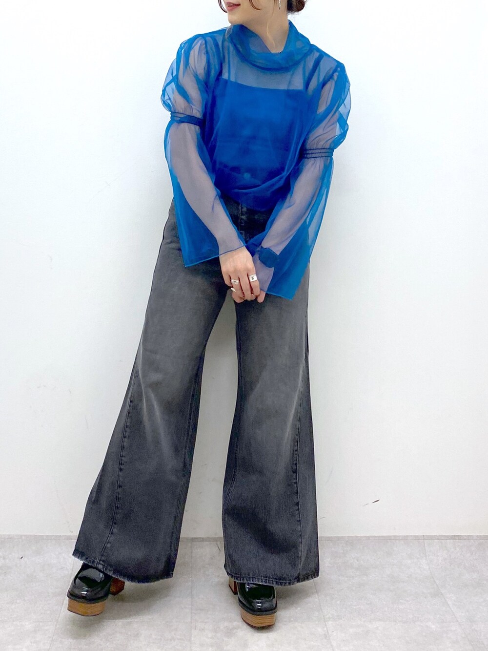 グレー系のテーラードジャケット、ブルー系のシャツ/ブラウス、ブラック系のデニムパンツを着用したレディースの秋コーディネートの7枚目の写真