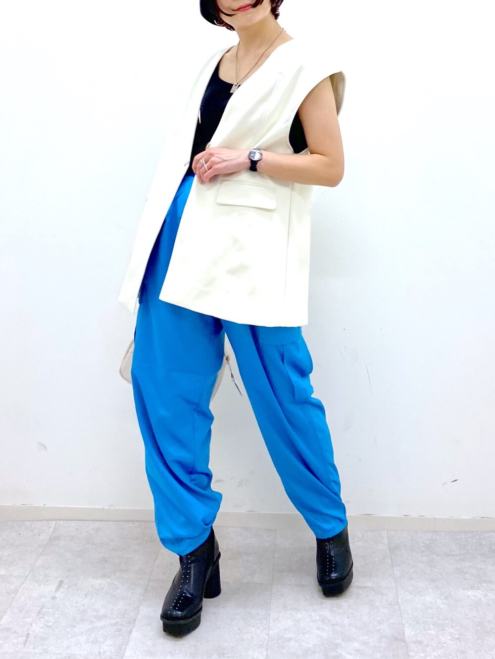 ホワイト系のショルダーバッグ、その他のパンツ、ブラック系のブーツを着用したレディースの秋コーディネートの4枚目の写真