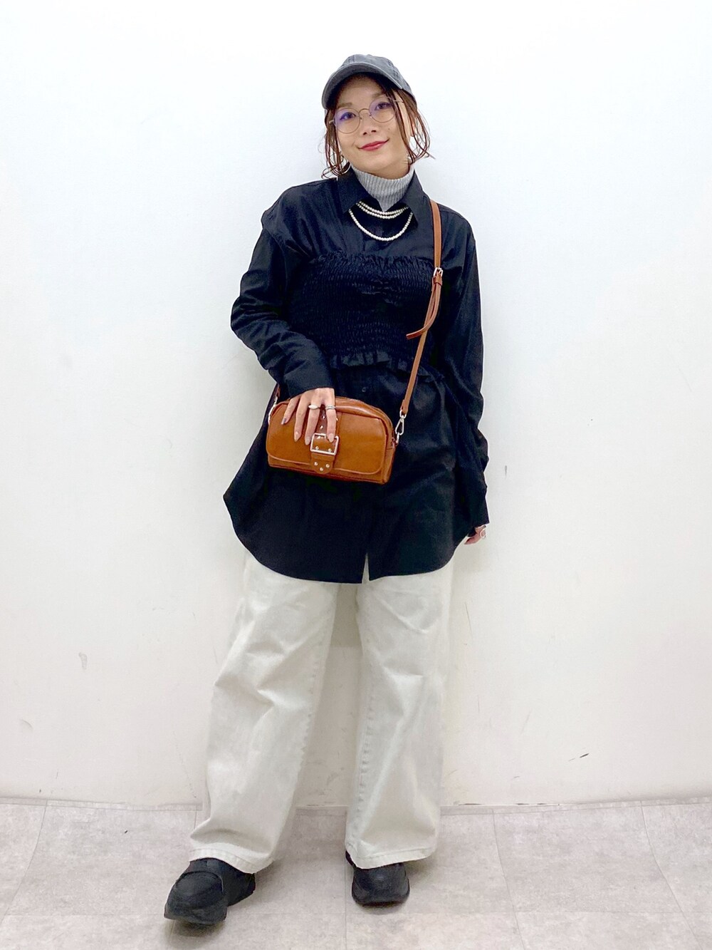 ブラック系のシャツ/ブラウス、ベージュ系のショルダーバッグ、グレー系のデニムパンツを着用したレディースの冬コーディネートの4枚目の写真