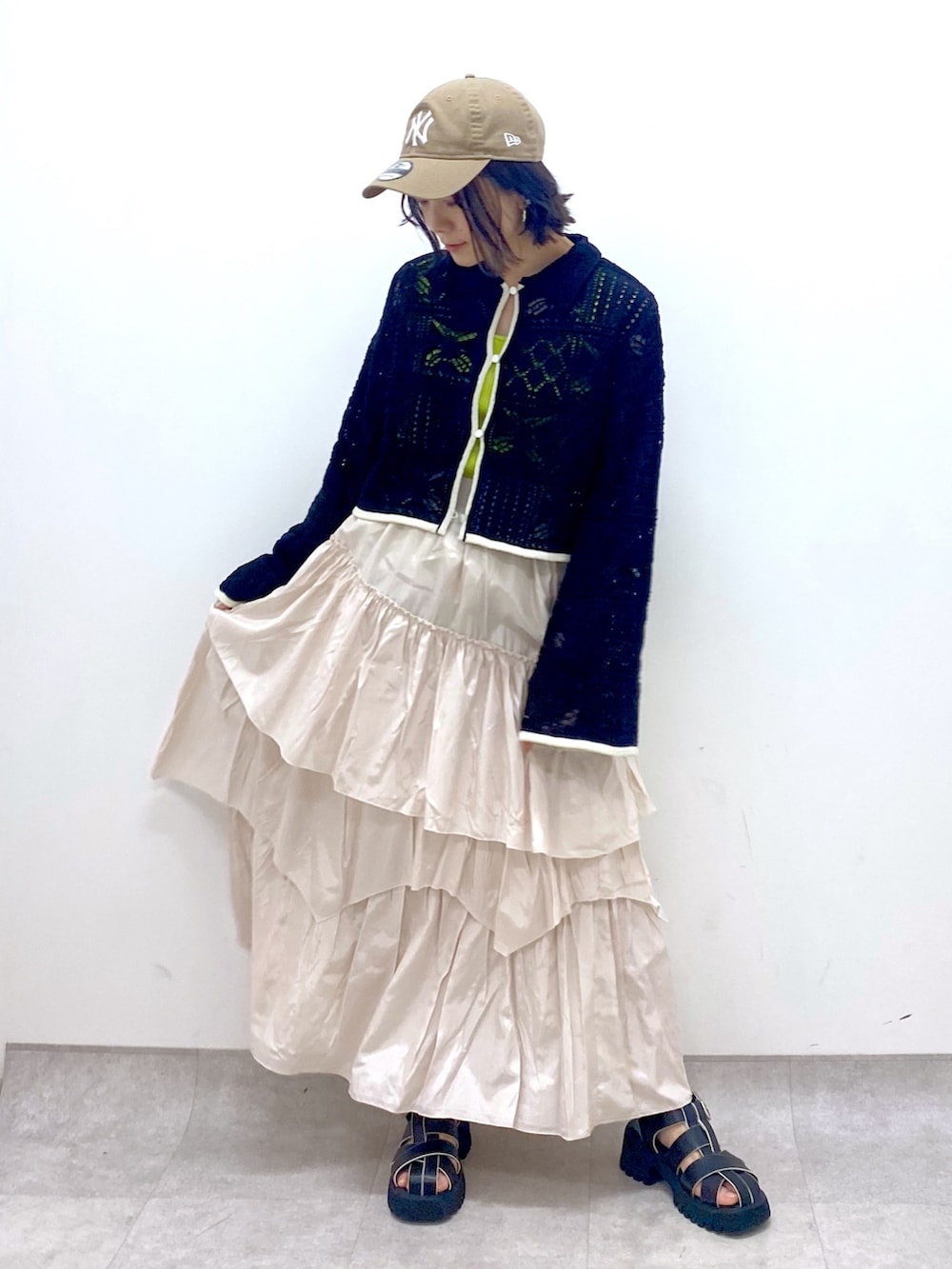 ホワイト系のスカート、ブラック系のサンダル、ブラック系のカーディガン/ボレロを着用したレディースの春コーディネートの4枚目の写真