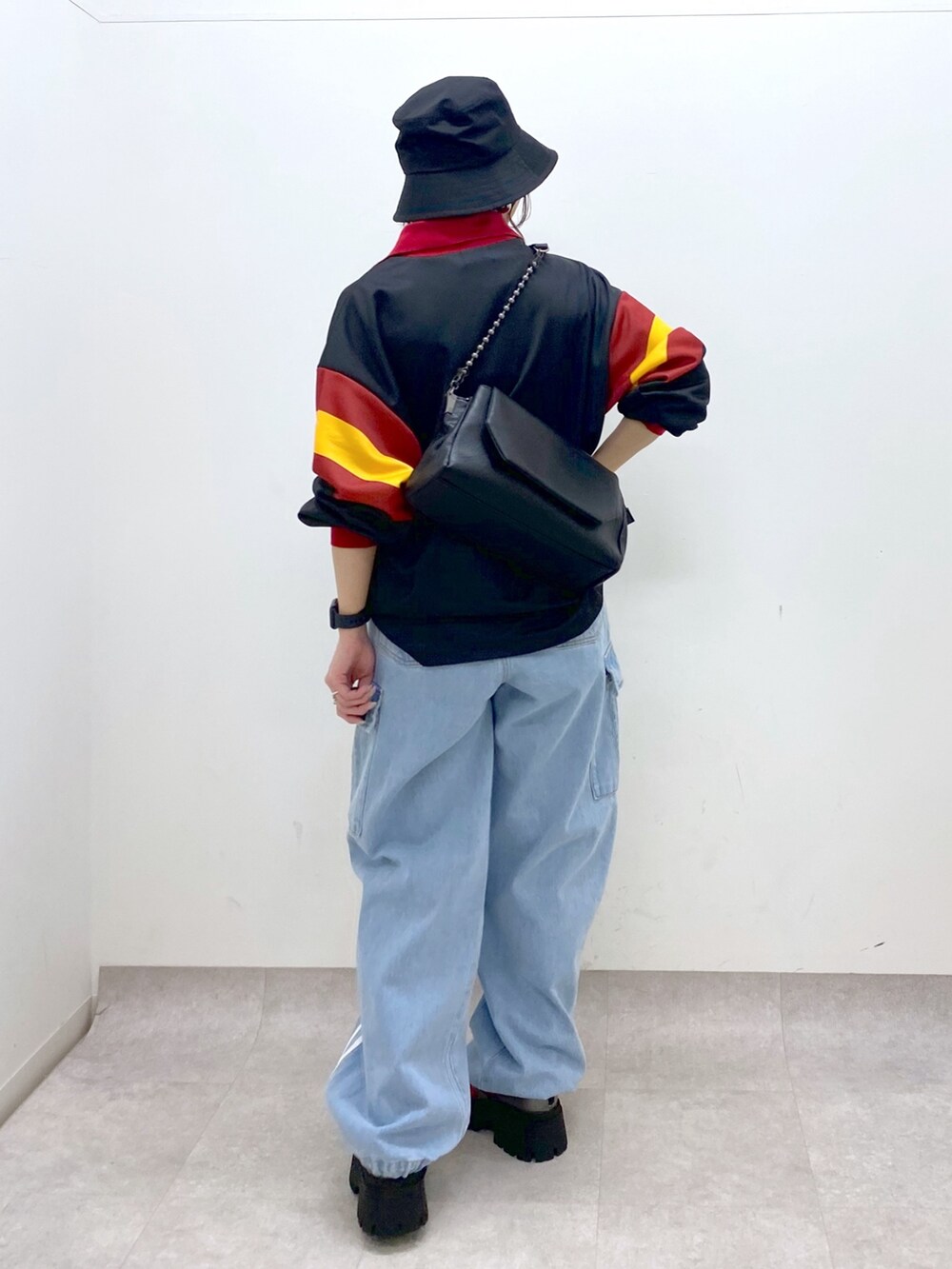ブラック系のシャツ/ブラウス、ブルー系のデニムパンツ、ブラック系のショルダーバッグを着用したレディースの春コーディネートの6枚目の写真