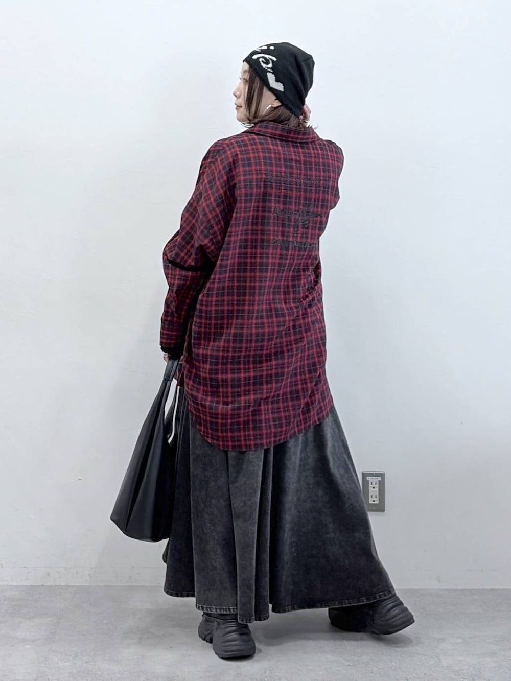 ブラック系のスニーカー、ブラック系のデニムスカート、ブラック系のトートバッグを着用したレディースの春コーディネートの7枚目の写真