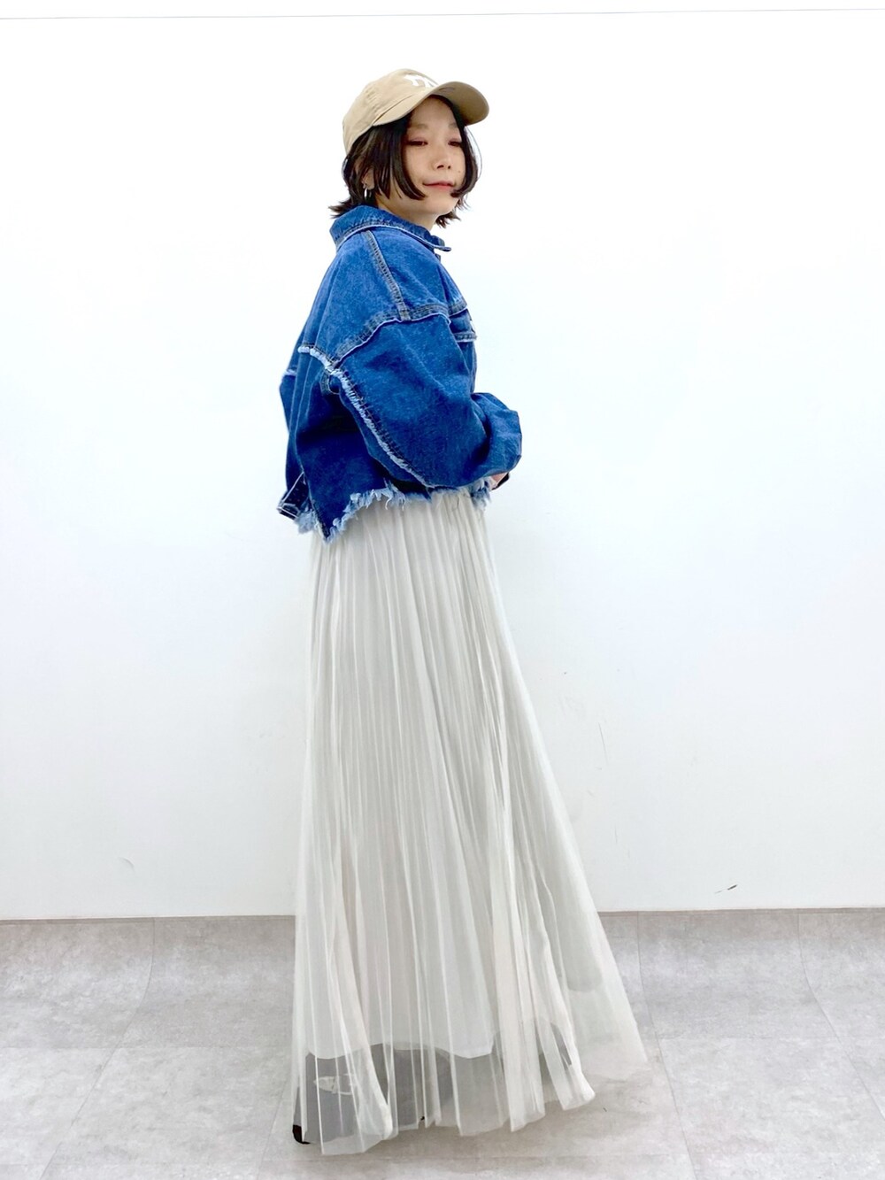 ホワイト系のスカート、ブラック系のトップス、ブルー系のジャケット/アウターを着用したレディースの春コーディネートの2枚目の写真