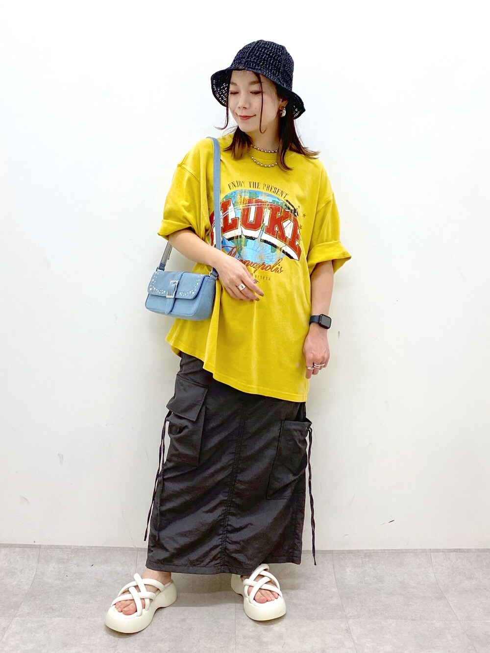 グレー系のスカート、ホワイト系のサンダル、ブルー系のハンドバッグを着用したレディースの春コーディネートの9枚目の写真