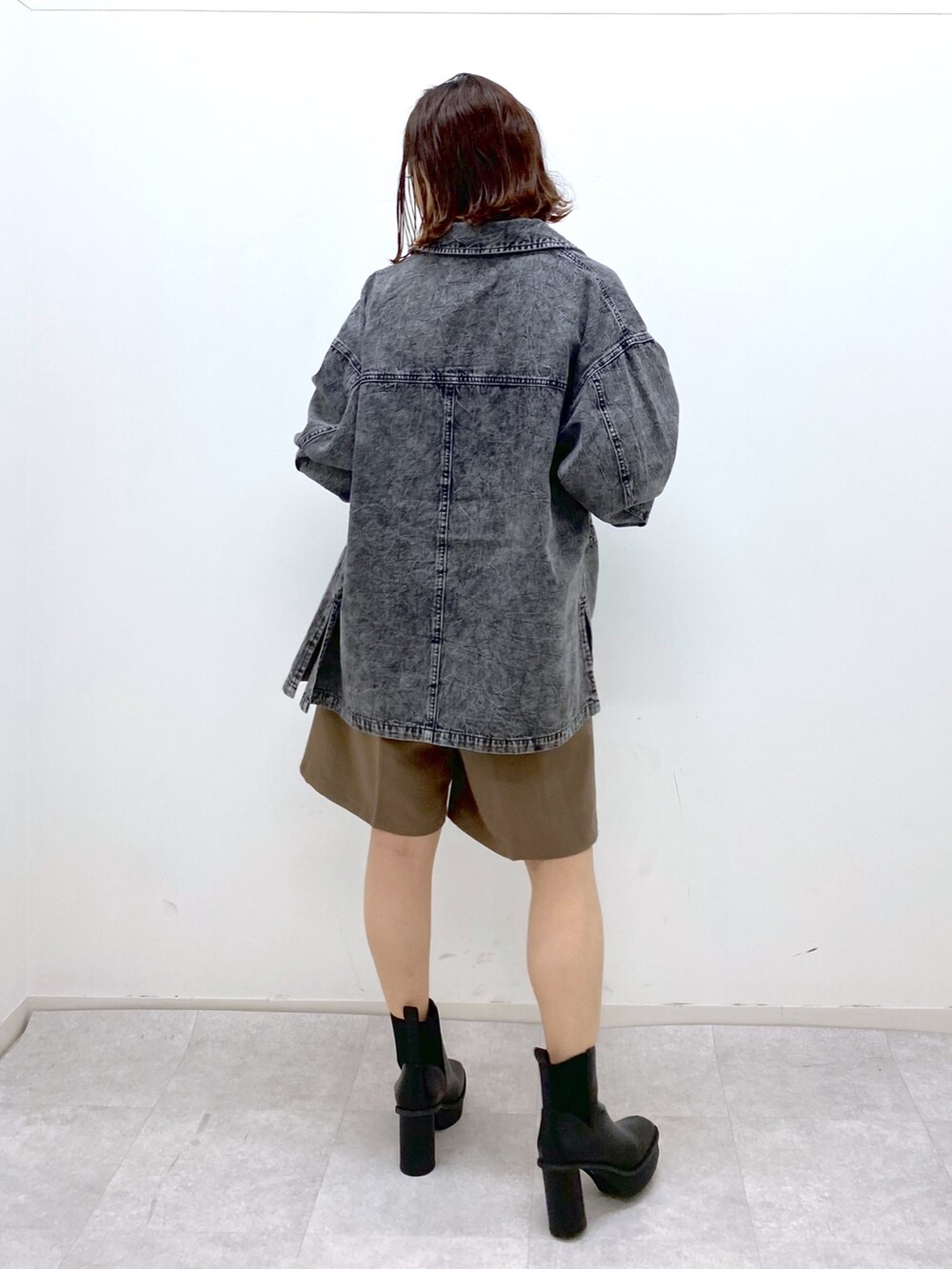 ブラウン系のパンツ、ブラック系のブーツ、ブラック系のショルダーバッグを着用したレディースの秋コーディネートの3枚目の写真