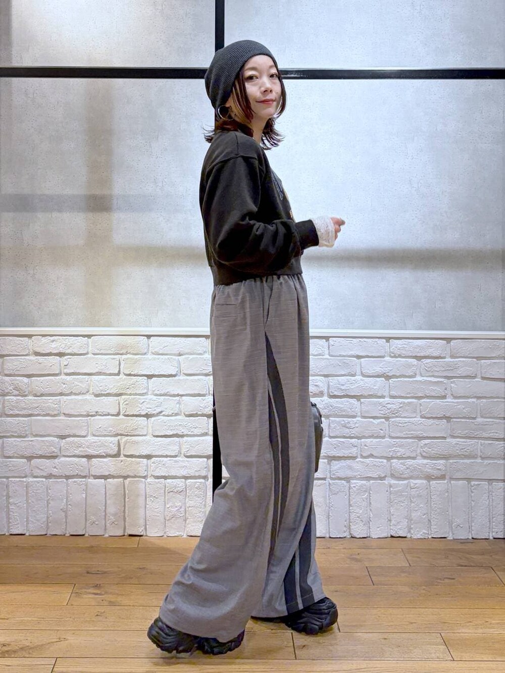 ブラック系のスニーカー、グレー系のスウェット、ブラック系のショルダーバッグを着用したレディースの冬コーディネートの5枚目の写真