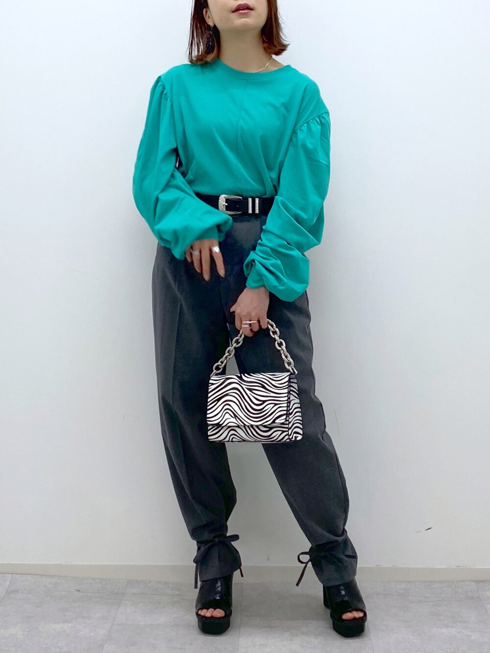 グリーン系のTシャツ/カットソー、グレー系のその他パンツ、その他のショルダーバッグを着用したレディースの春コーディネートの5枚目の写真