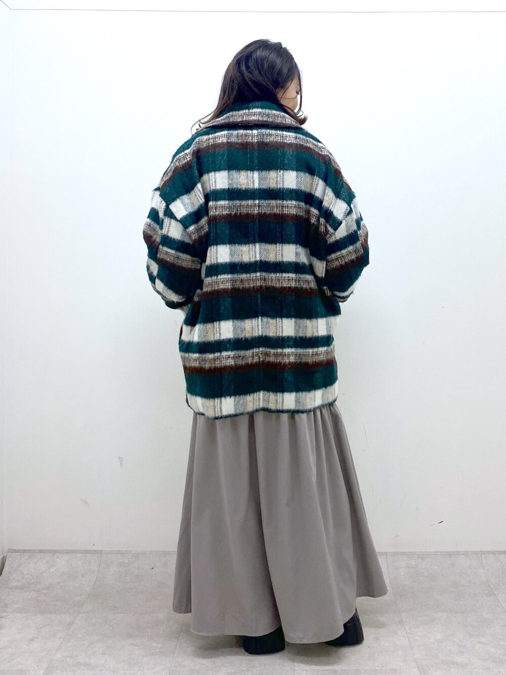 グリーン系のその他アウター、ホワイト系のニット/セーター、ホワイト系のワンピースを着用したレディースの冬コーディネートの5枚目の写真