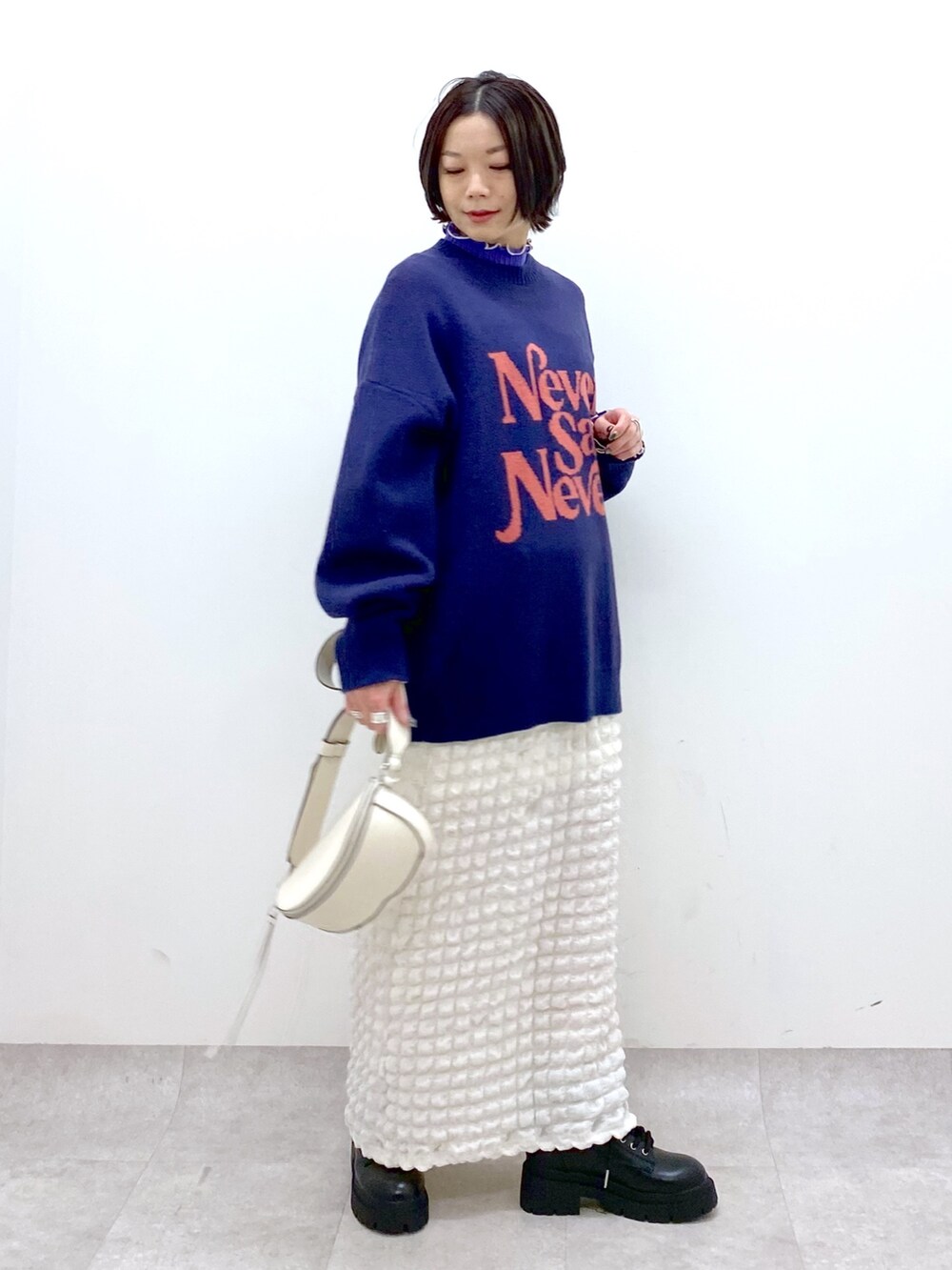 ホワイト系のスカート、パープル系のニット/セーター、パープル系のニット/セーターを着用したレディースの冬コーディネートの2枚目の写真