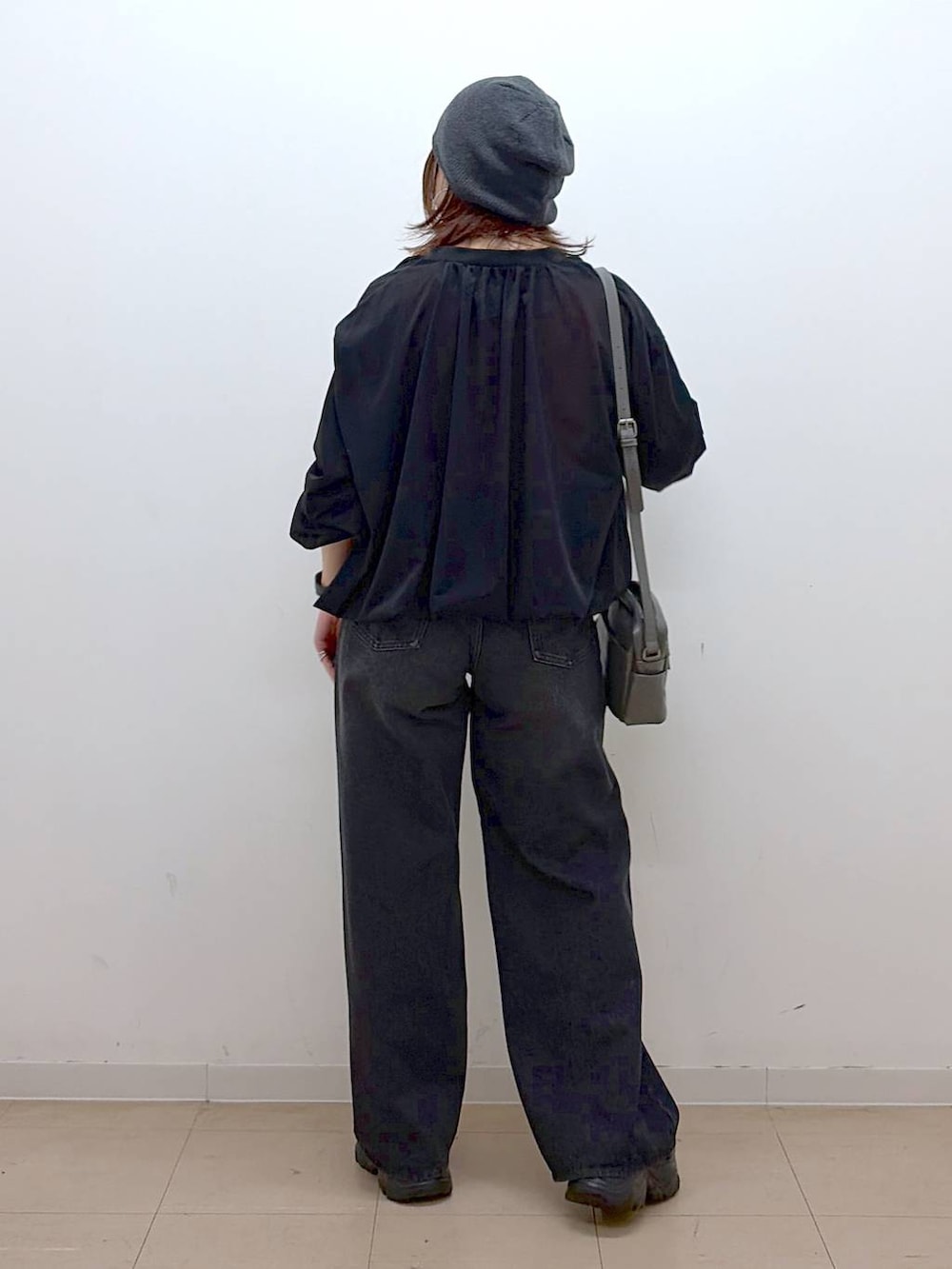 ホワイト系のキャミソール、ブラック系のデニムパンツ、ブラック系のブルゾンを着用したレディースの春コーディネートの7枚目の写真