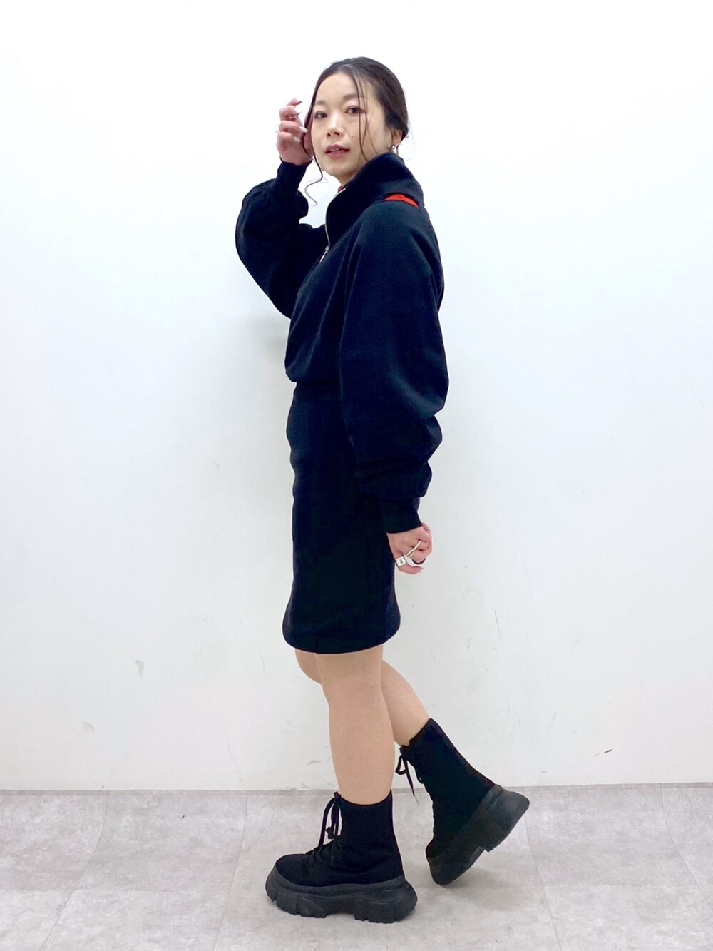 ブラック系のワンピース、レッド系のニット/セーター、ベージュ系のボストンバッグを着用したレディースの冬コーディネートの3枚目の写真