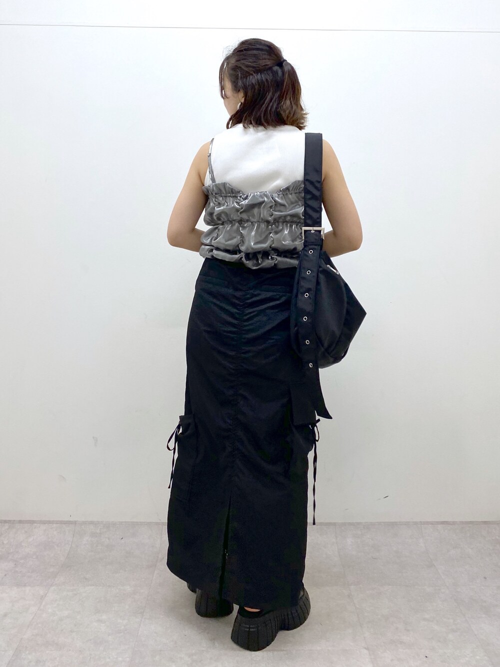 ブラック系のスニーカー、ブラック系のスカート、ブラック系のショルダーバッグを着用したレディースの夏コーディネートの6枚目の写真