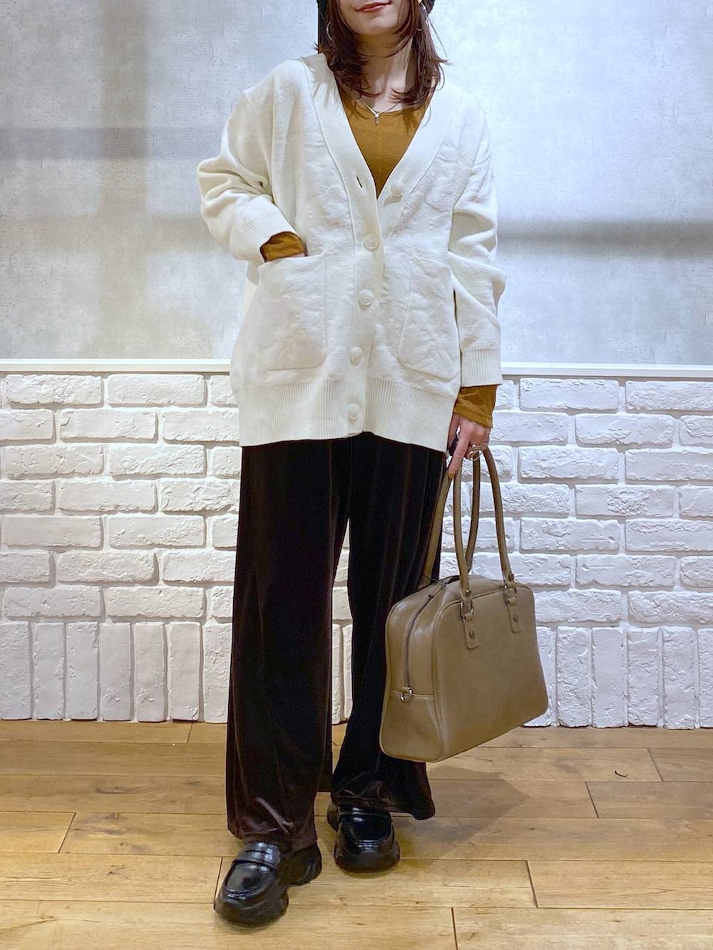 ベージュ系のボストンバッグ、イエロー系のTシャツ/カットソー、ブラック系のローファーを着用したレディースの冬コーディネートの3枚目の写真