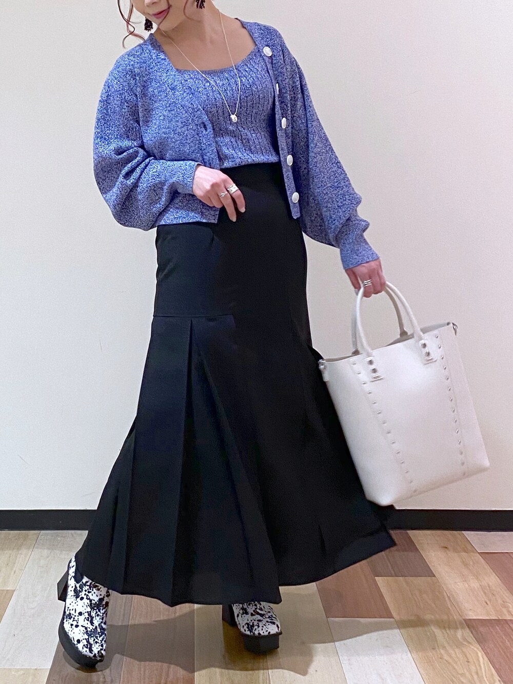 ブラック系のスカート、ホワイト系のブーツ、ホワイト系のショルダーバッグを着用したレディースの冬コーディネートの5枚目の写真