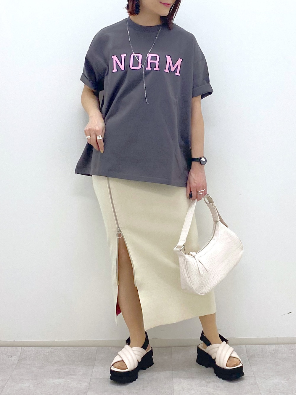ブラック系のブルゾン、グレー系のTシャツ/カットソー、ホワイト系のスカートを着用したレディースの春コーディネートの5枚目の写真