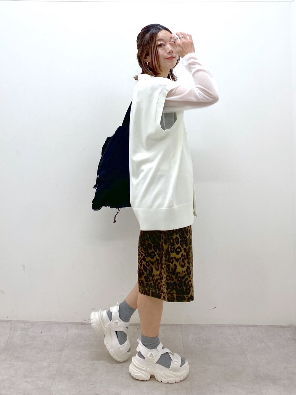 ホワイト系のカーディガン/ボレロ、ホワイト系のTシャツ/カットソー、ブラック系のバックパック/リュックを着用したレディースの春コーディネートの7枚目の写真