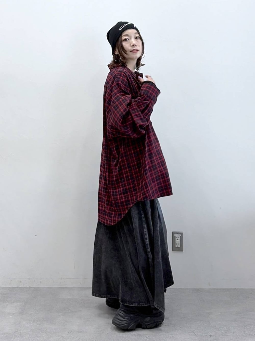 ブラック系のスニーカー、ブラック系のデニムスカート、ブラック系のトートバッグを着用したレディースの春コーディネートの9枚目の写真