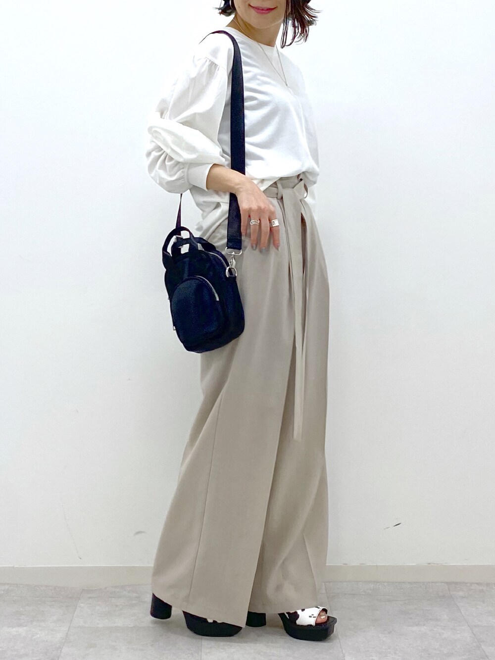 ホワイト系のTシャツ/カットソー、ベージュ系のその他パンツ、ブラック系のショルダーバッグを着用したレディースの春コーディネートの5枚目の写真