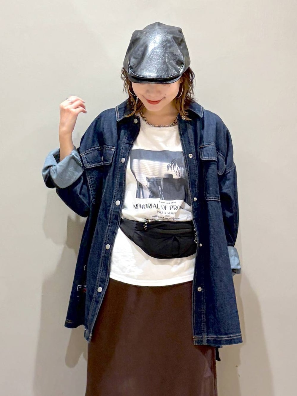 ブルー系のシャツ/ブラウス、ブラウン系のスカート、ブラック系のスニーカーを着用したレディースの夏コーディネートの2枚目の写真
