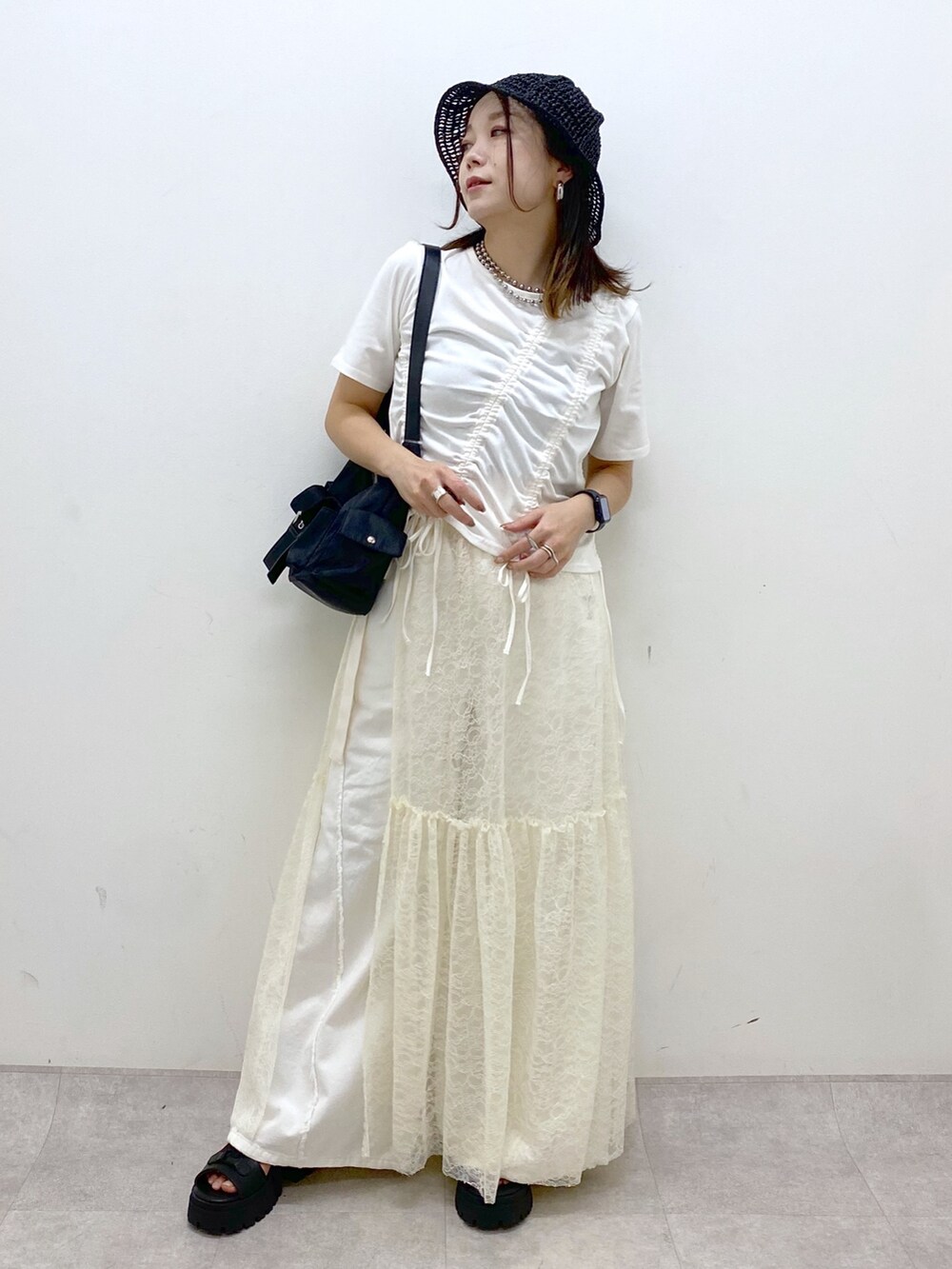 ホワイト系のTシャツ/カットソー、ブラック系のサンダル、ホワイト系のデニムパンツを着用したレディースの春コーディネートの8枚目の写真