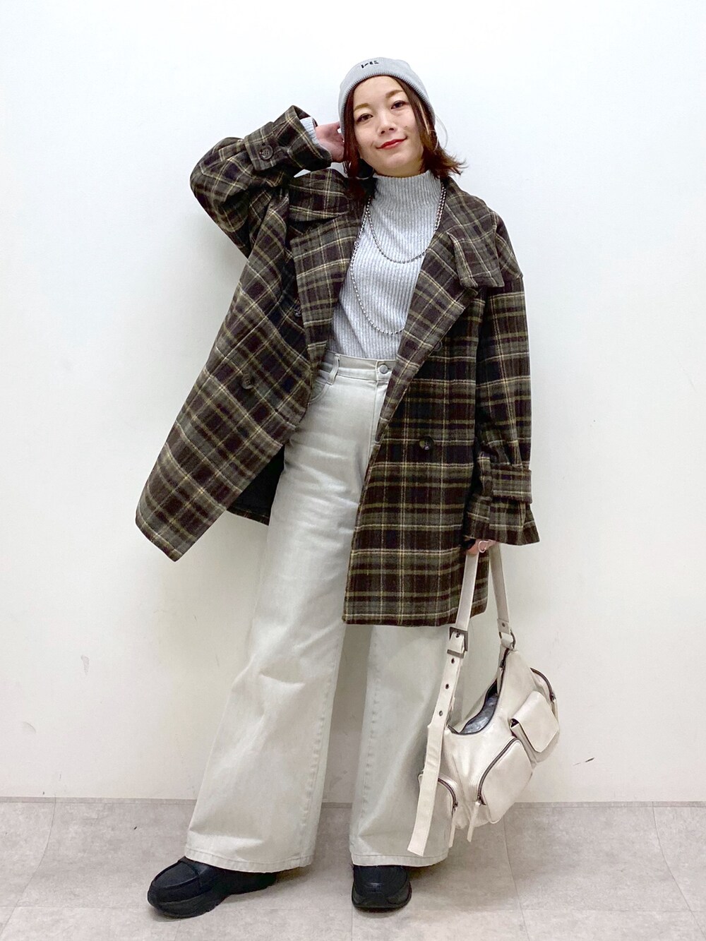 ブラウン系のテーラードジャケット、グレー系のデニムパンツ、ホワイト系のショルダーバッグを着用したレディースの冬コーディネートの9枚目の写真