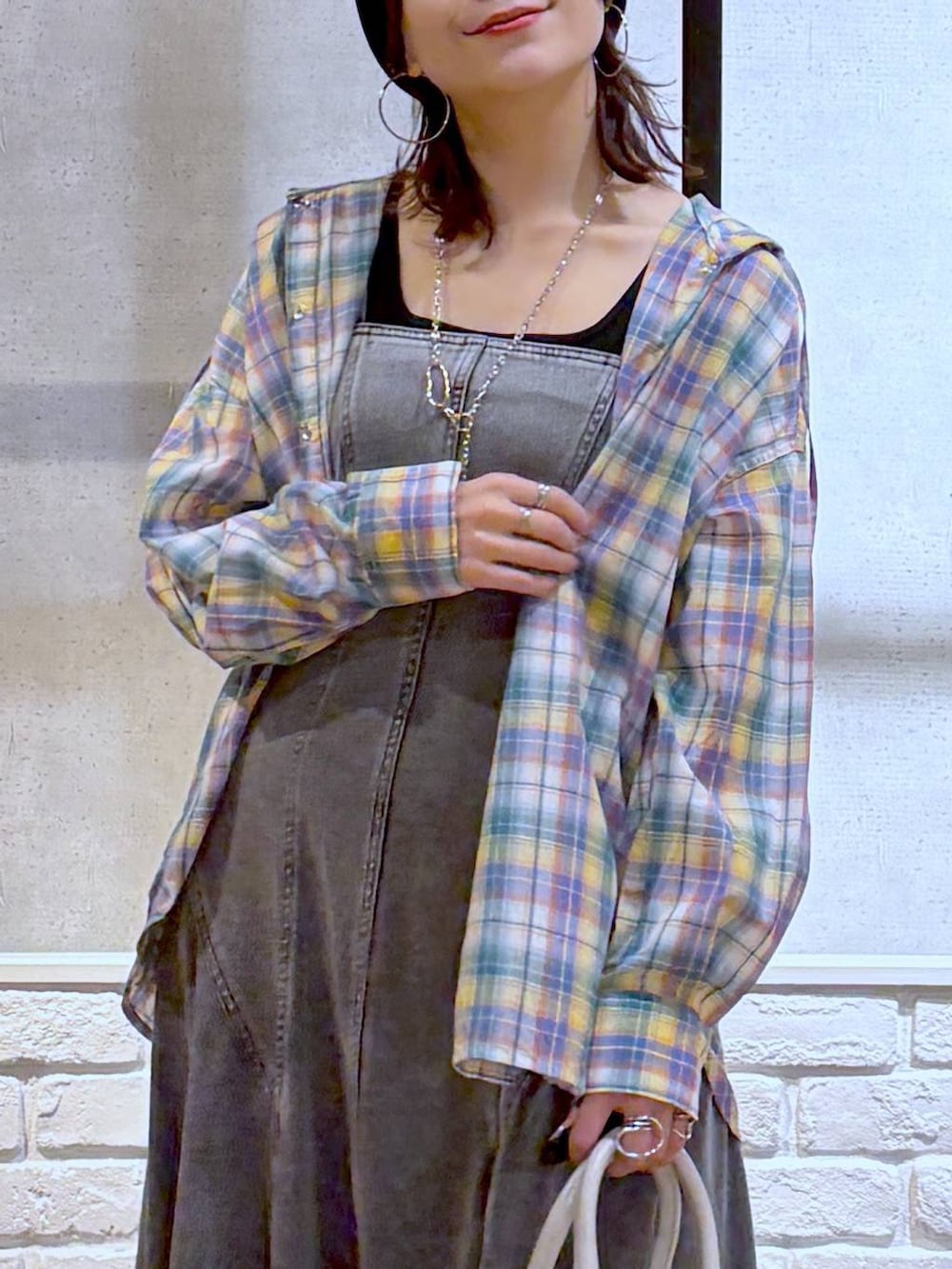 ブラック系のスニーカー、ホワイト系のボストンバッグ、ブラック系のワンピースを着用したレディースの春コーディネートの2枚目の写真