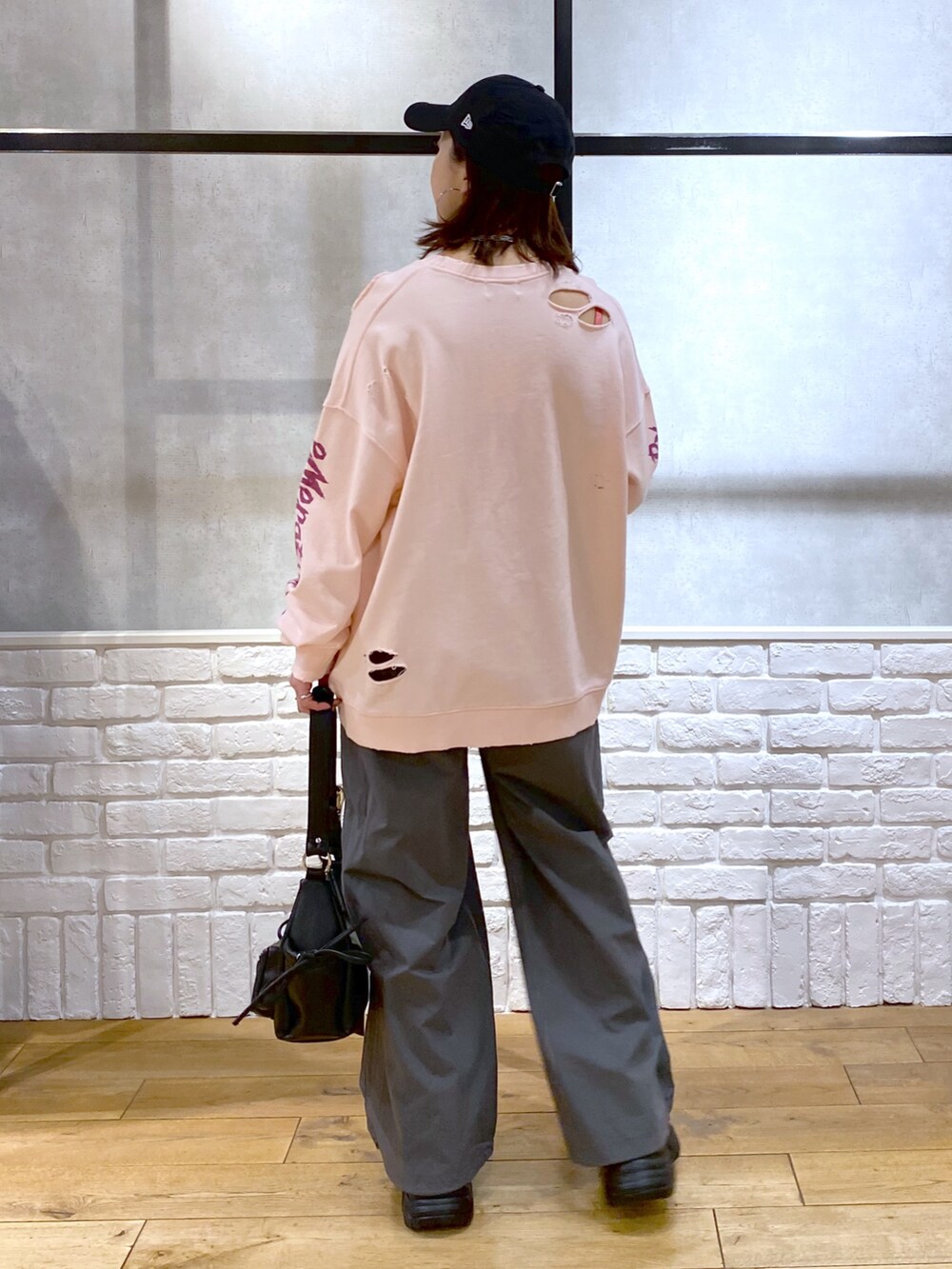 ピンク系のスウェット、グレー系のカーゴパンツ、ブラック系のショルダーバッグを着用したレディースの春コーディネートの6枚目の写真